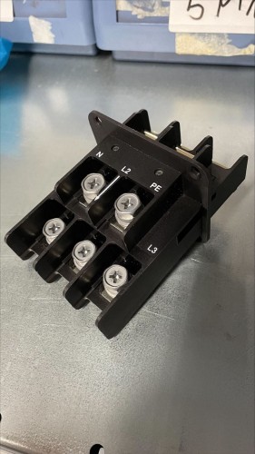 Black plastic connector with metal screws of irregular shape